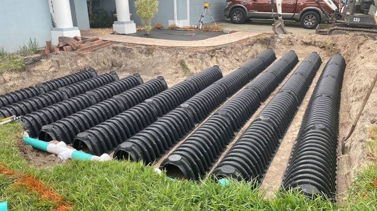 Real chamber drainfield installation by Anytime Septic — rows of plastic leaching chambers set in excavated trenches beside a Central Florida home